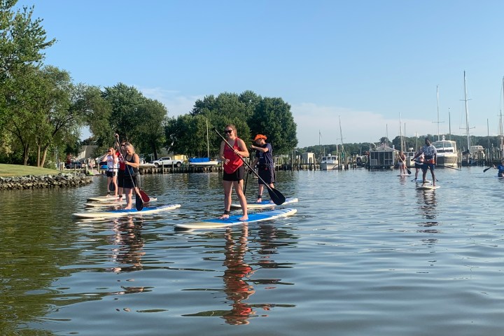 a group of people riding on the back of a boat in the water