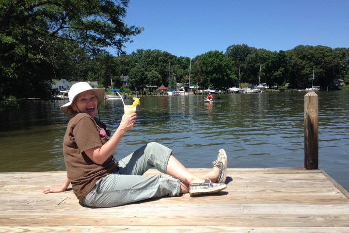 a man sitting next to a body of water