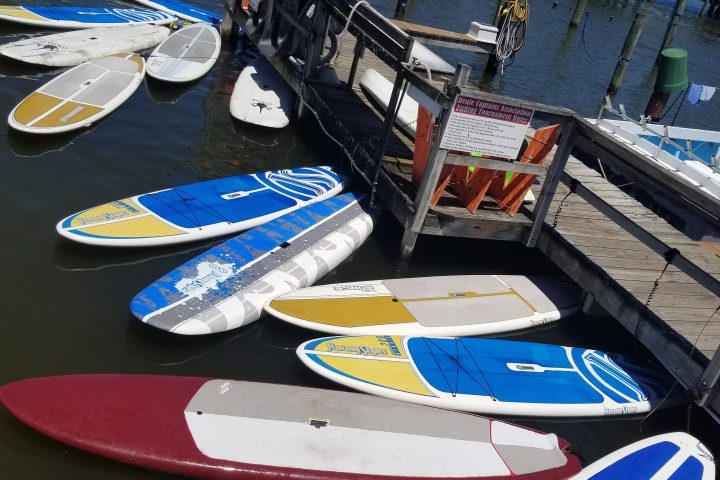 a blue and white boat sitting next to a body of water