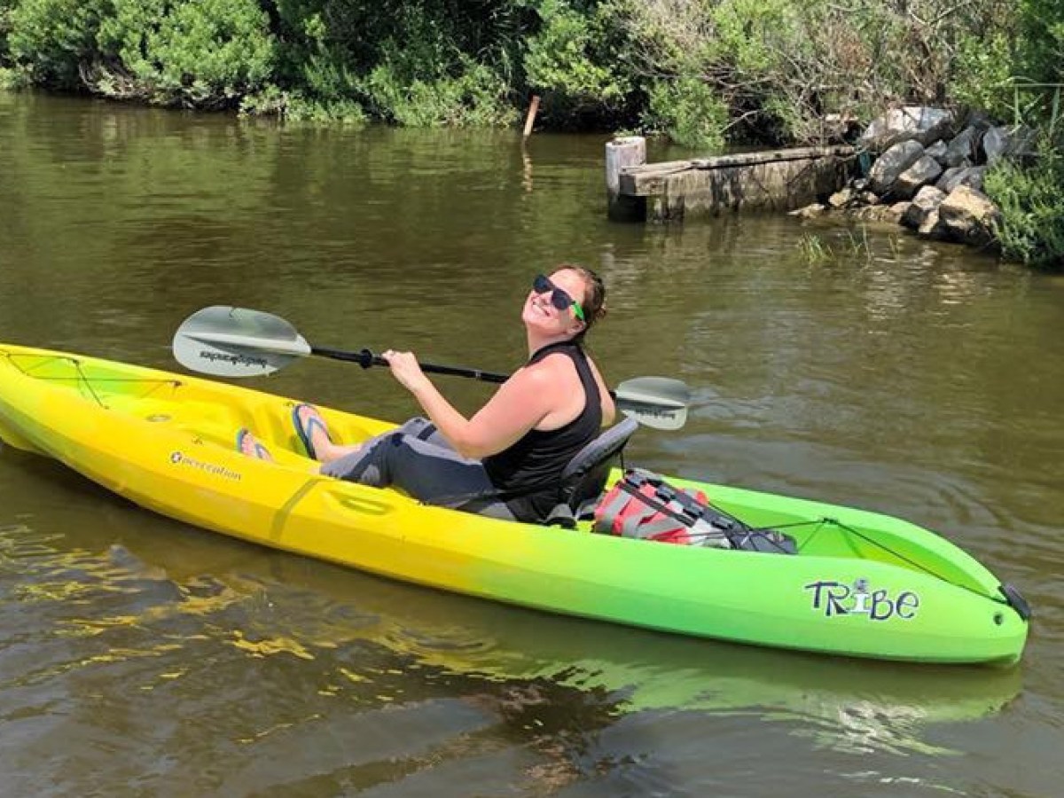 A happy visitor in a single person kayak exploring