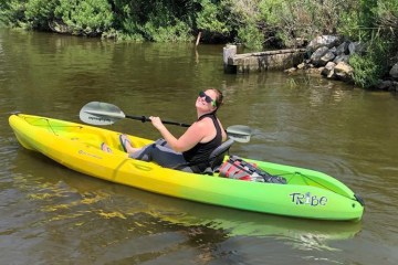 A happy visitor in a single person kayak exploring