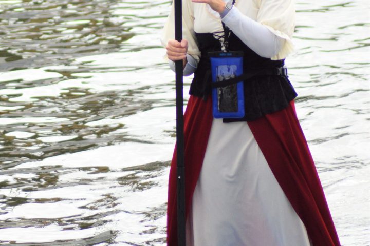 a woman standing next to a body of water