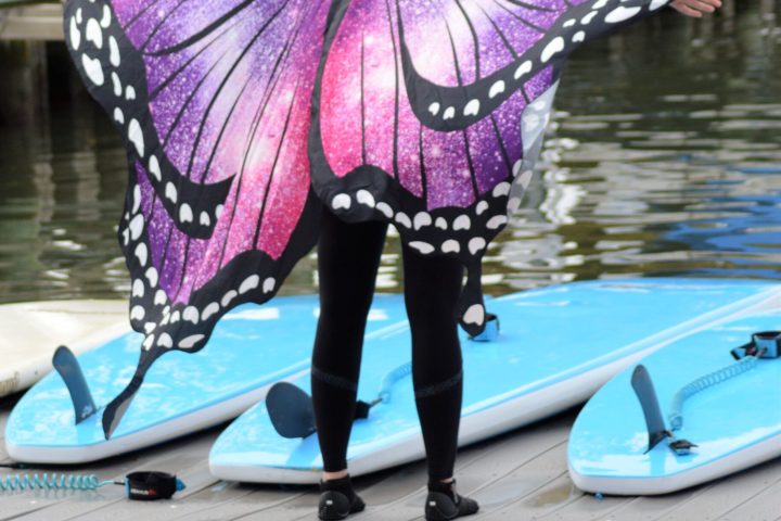 a small boat in a body of water with a pink umbrella