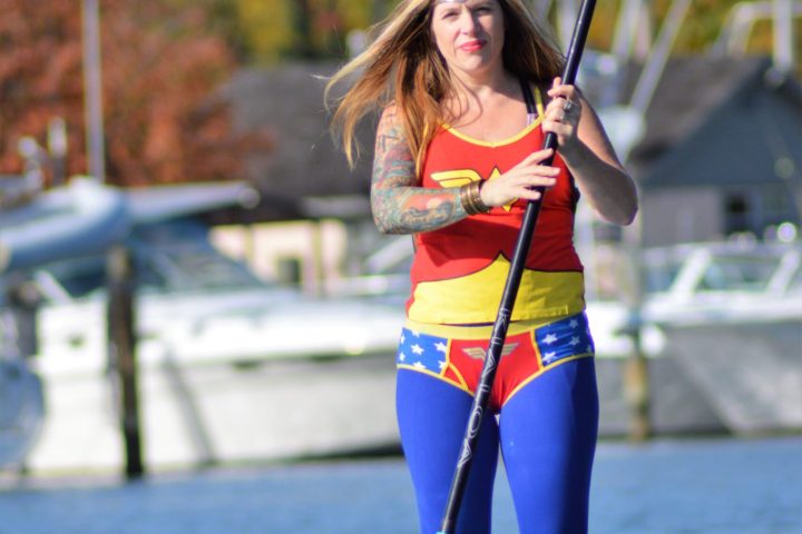 a woman standing next to a body of water