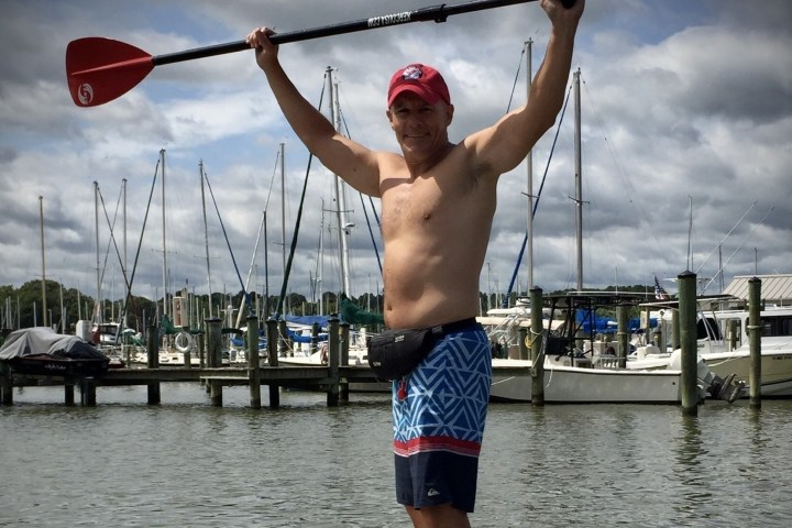 a man standing next to a body of water