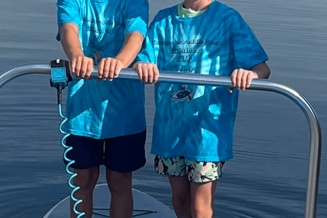 a woman standing next to a body of water